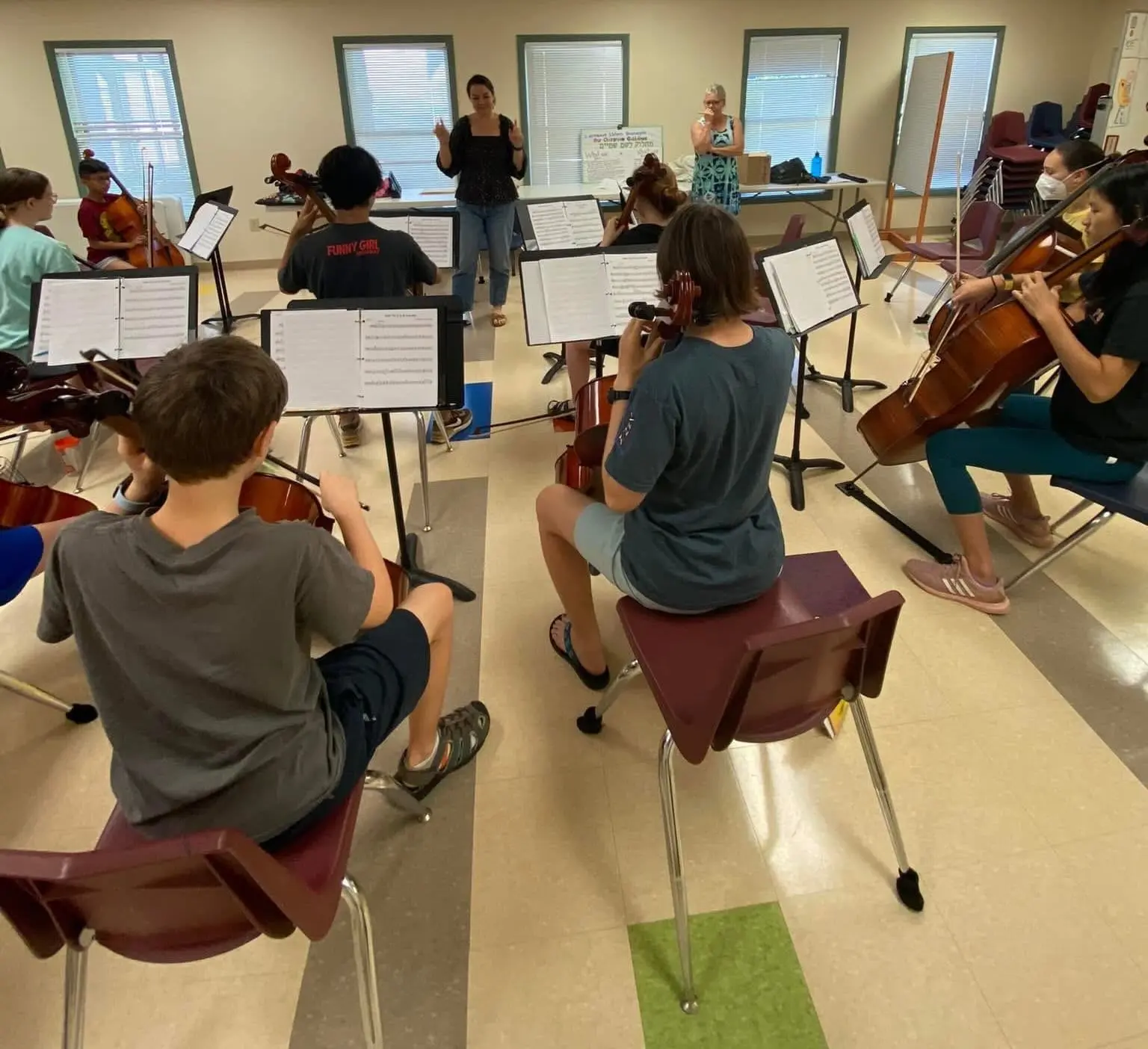 Students playing cello together in a group class